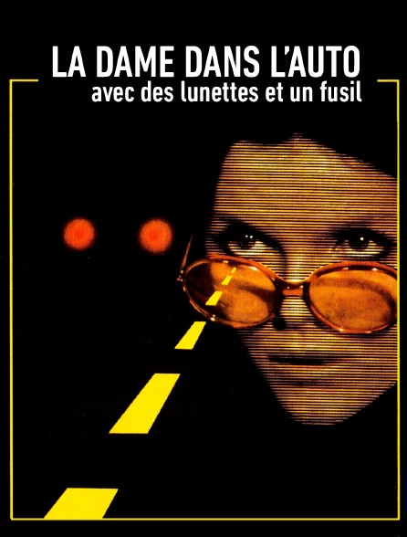 La dame dans l'auto avec des lunettes et un fusil